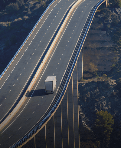Truck driving on elevated highway bridge.